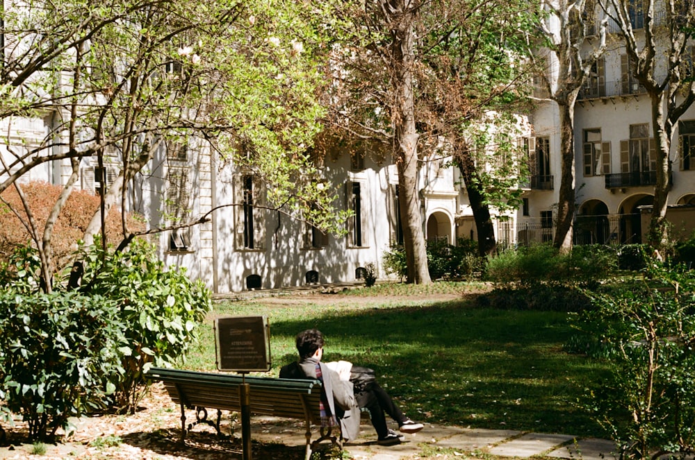 a man sitting on a bench in front of a building