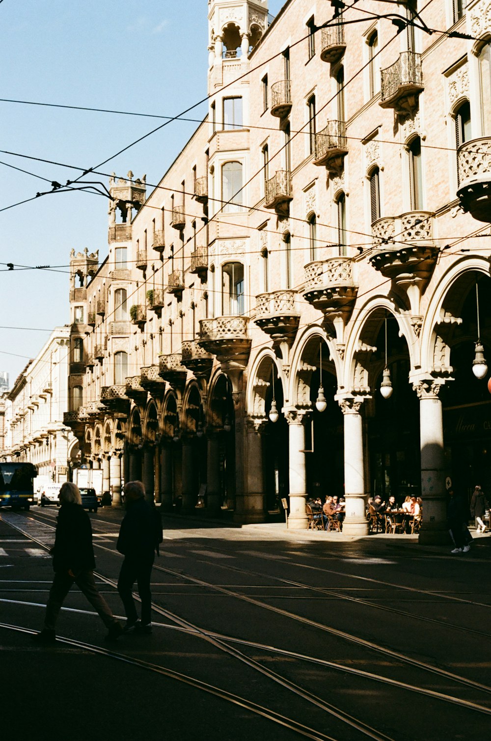 a couple of people walking down a street next to a tall building