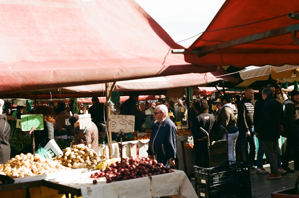 a group of people shopping at an outdoor market