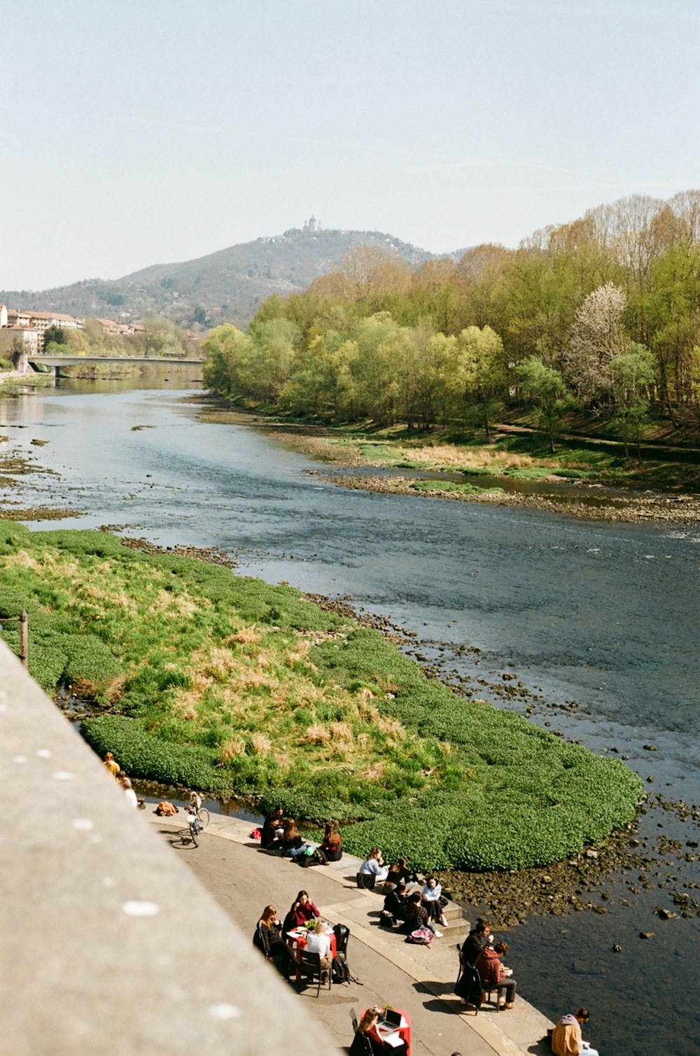 a group of people sitting next to a river