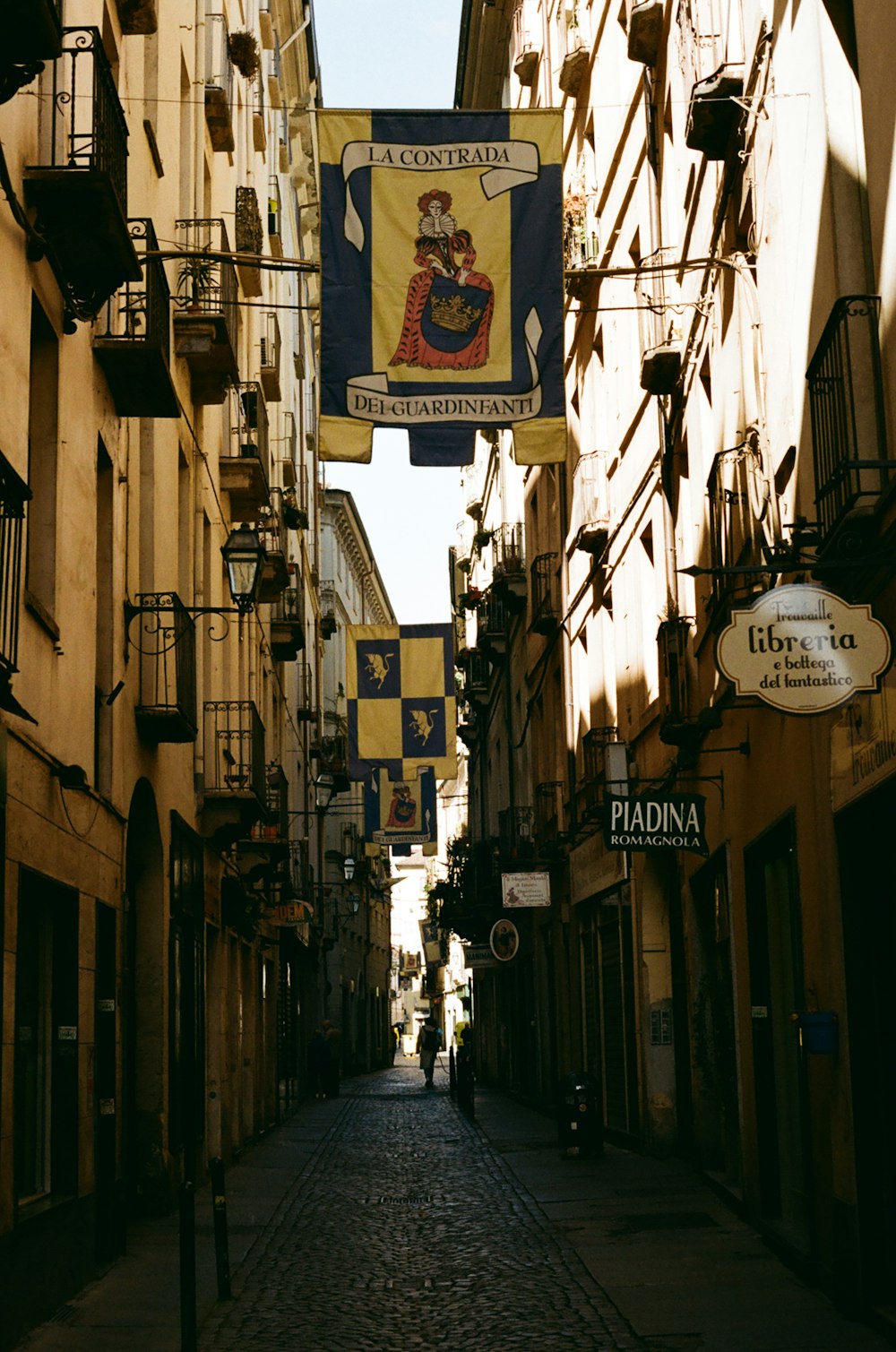 a cobblestone street lined with tall buildings