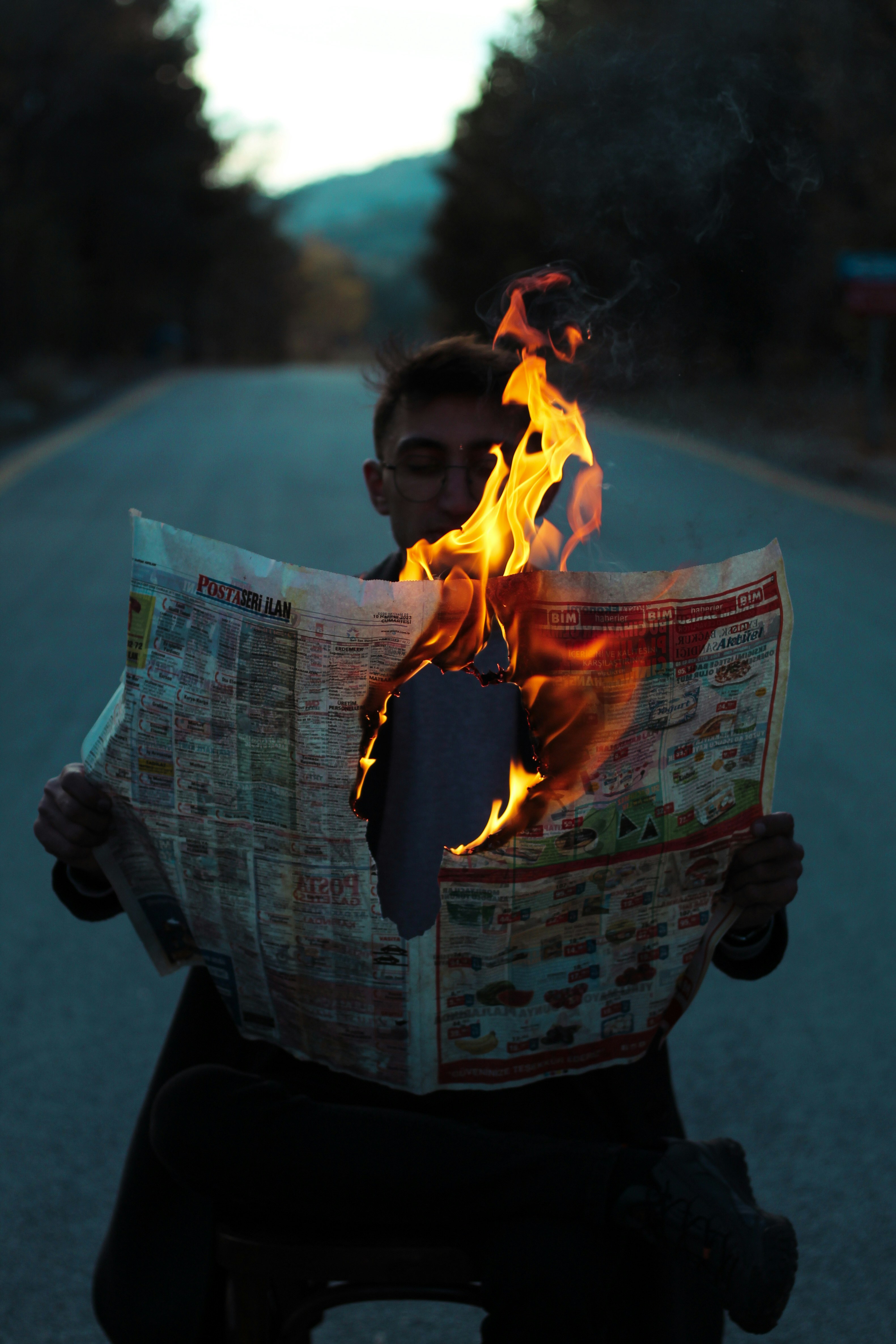 A man reading a newspaper with flames coming out of it photo – Free ...