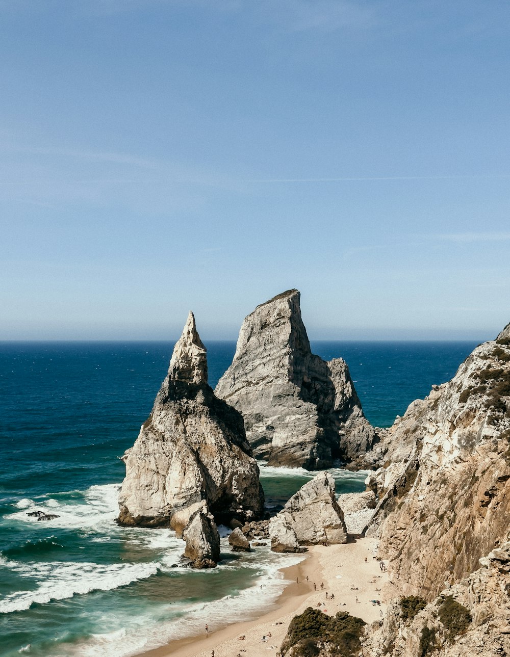 a couple of large rocks sitting on top of a beach