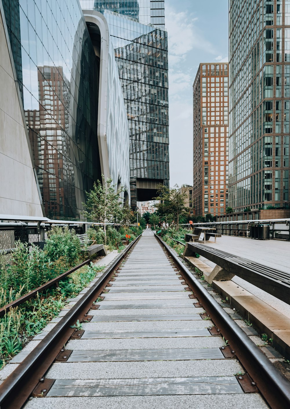 a set of train tracks in front of tall buildings