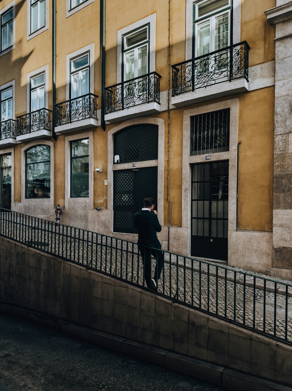 a man walking down a street next to a tall building