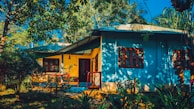Wide shot of a freshly painted house with vibrant colors under bright sunlight.