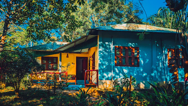 Brightly painted house exterior bathed in sunlight with fresh blue paint