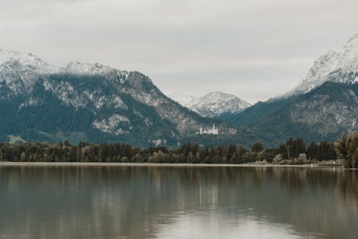 A mystical fantasy landscape with towering mountains and a shimmering lake.