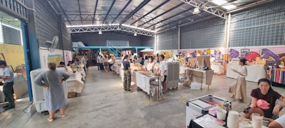 A community gathering exchanging goods and services in a friendly, welcoming environment with purple and tan decor.