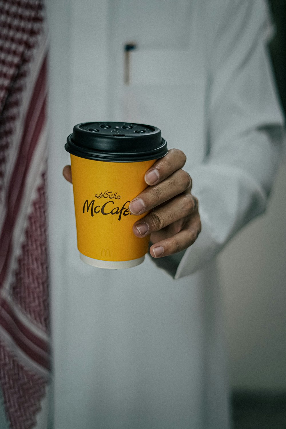 a person holding a cup of coffee in their hand