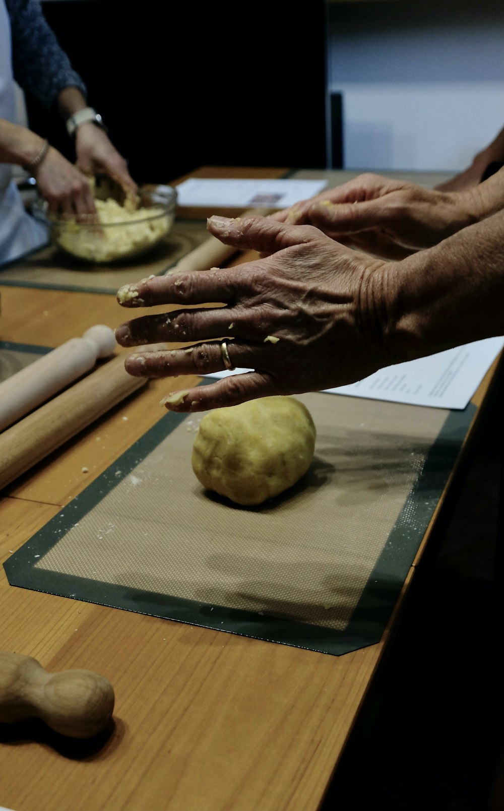a group of people kneading dough on top of a table