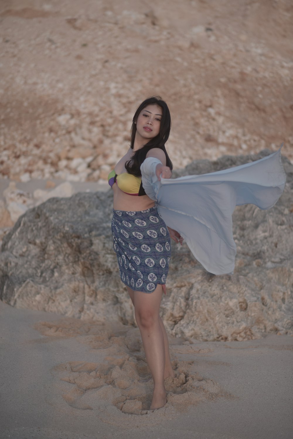 a woman holding a banana and wearing a skirt