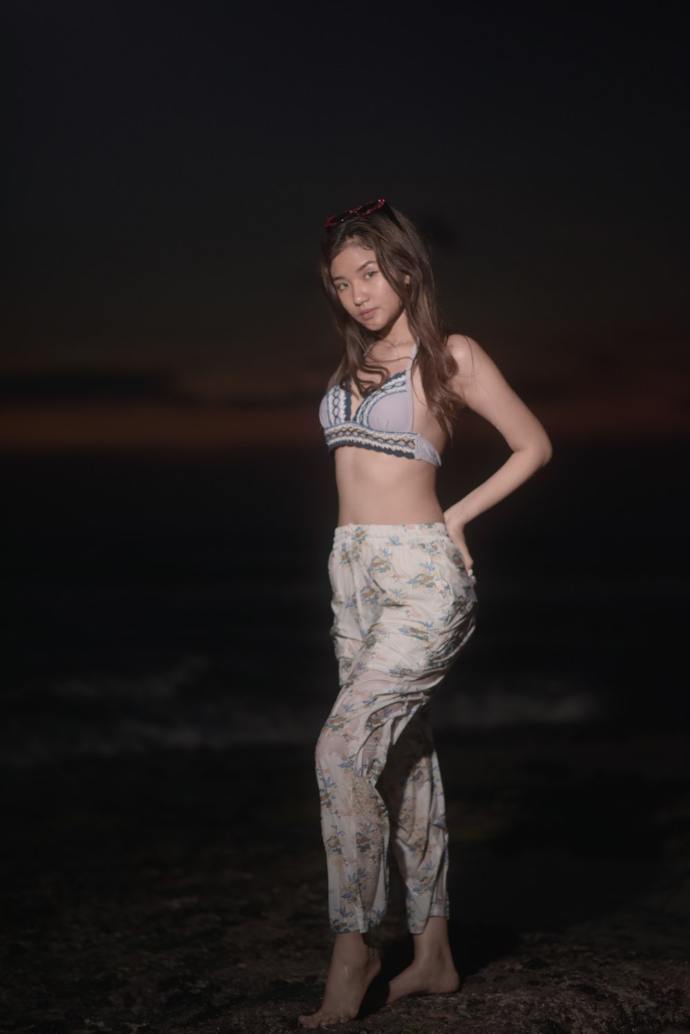 a woman standing on a beach at night