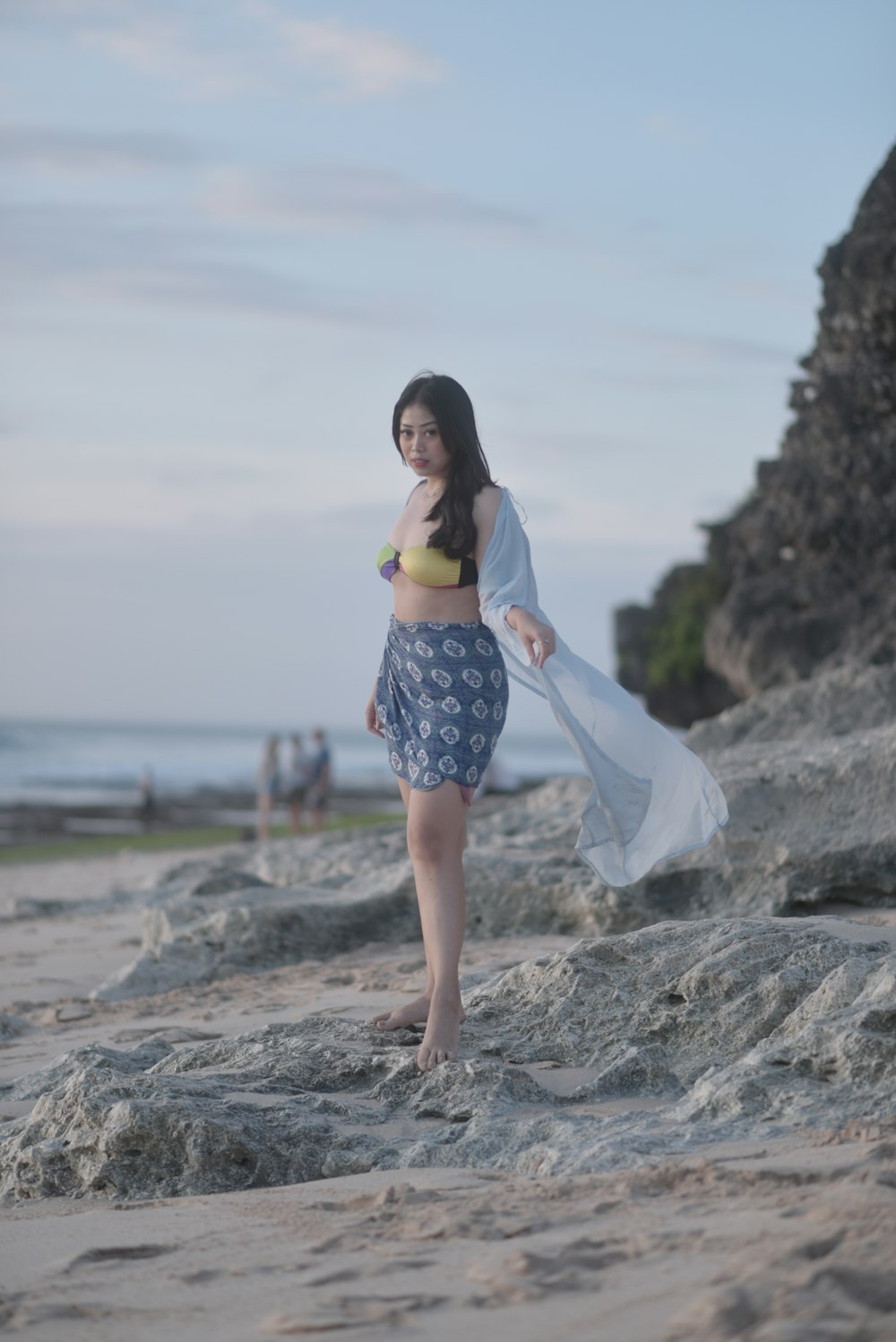 a woman standing on top of a sandy beach