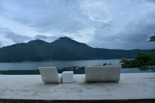 Sunlit porch overlooking the lake, furnished with comfortable chairs and a small table.