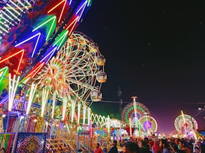 a carnival with a ferris wheel at night