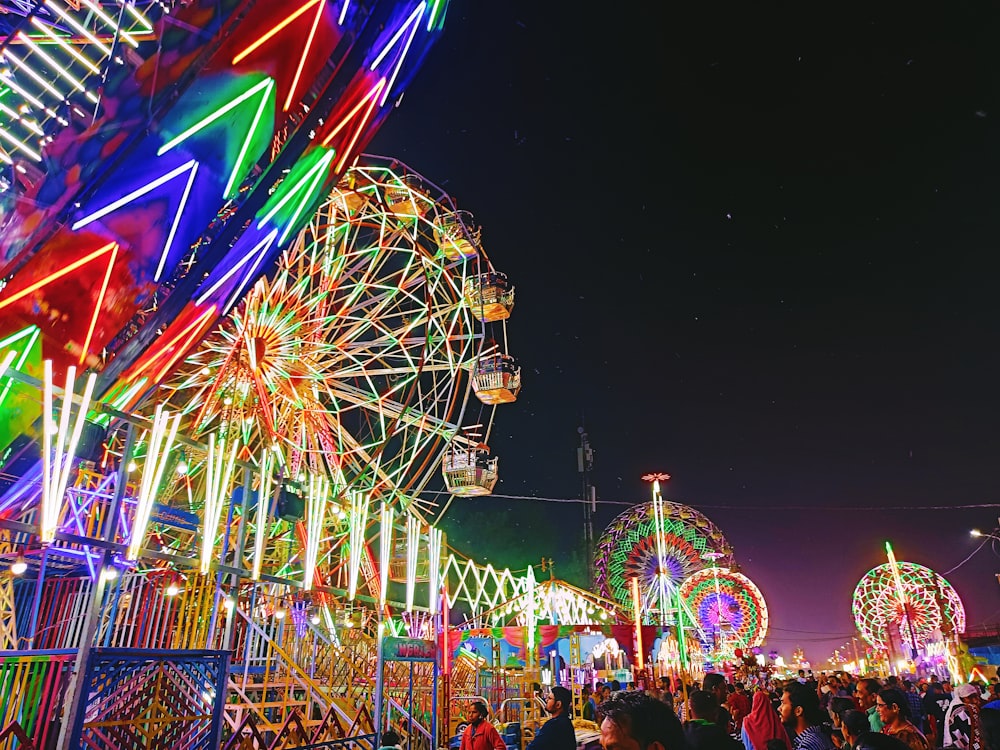 a carnival with a ferris wheel at night