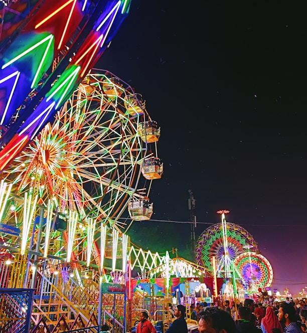 a carnival with a ferris wheel at night