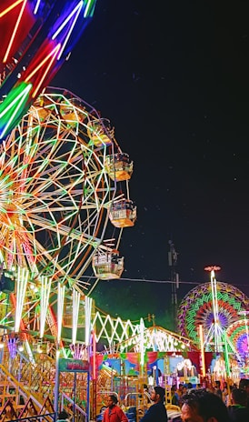 a carnival with a ferris wheel at night