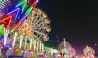 a carnival with a ferris wheel at night