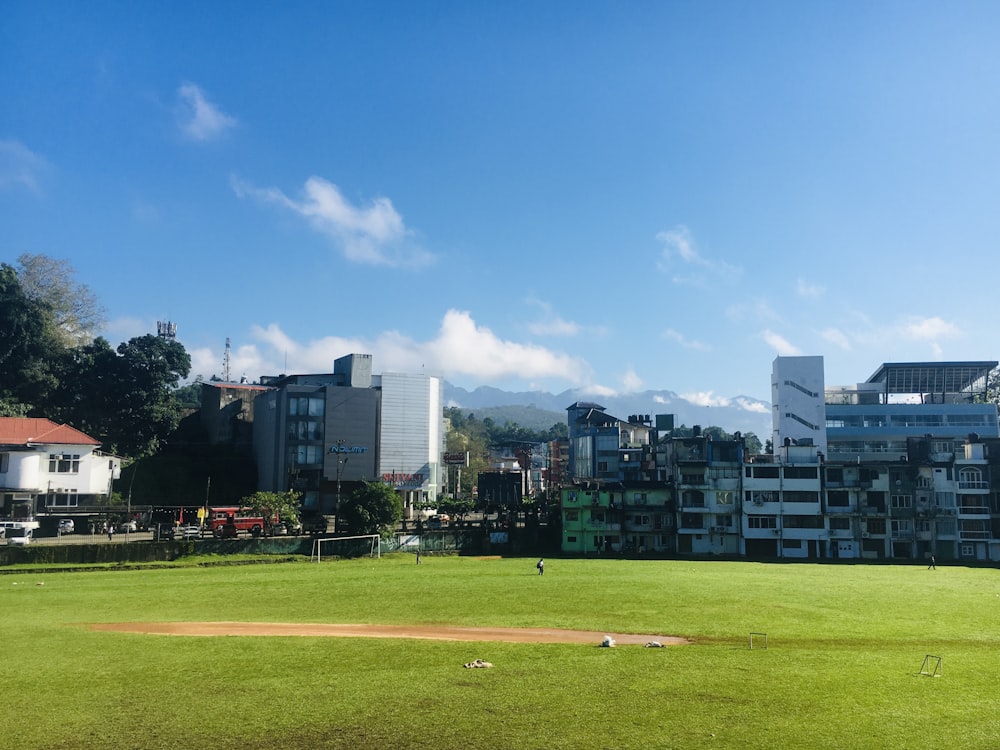 a baseball field with buildings in the background