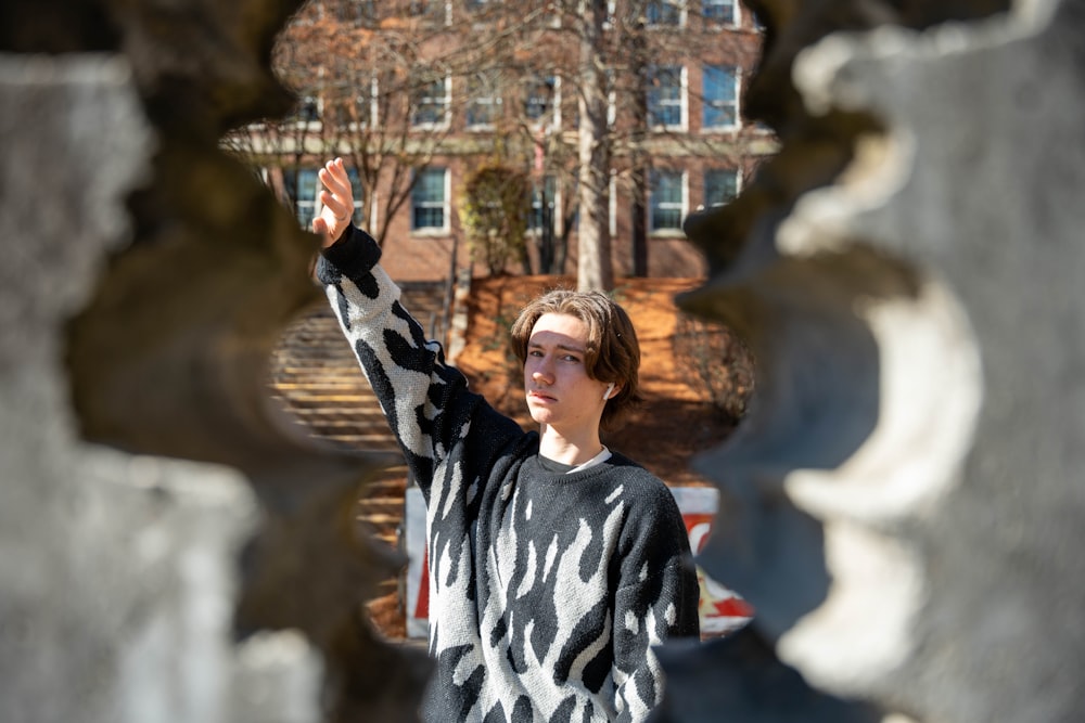 a young man standing in front of a building