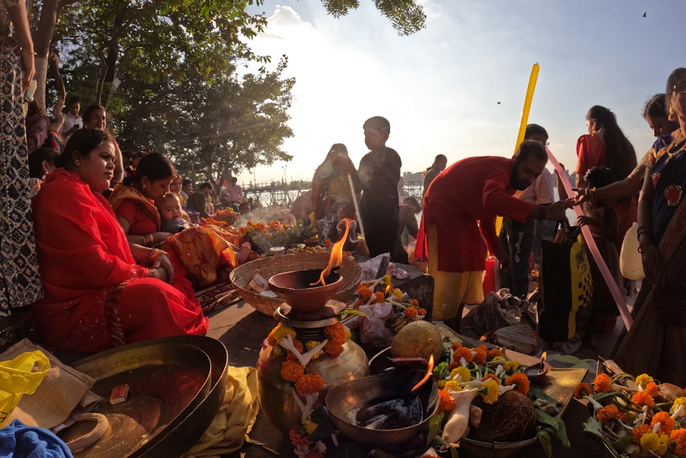 a group of people standing around a table filled with food