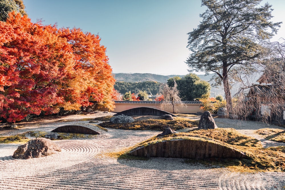 a japanese garden with a stone bridge in the background