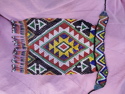 Brightly dyed adire textile showing intricate tie-dye patterns in indigo and white.