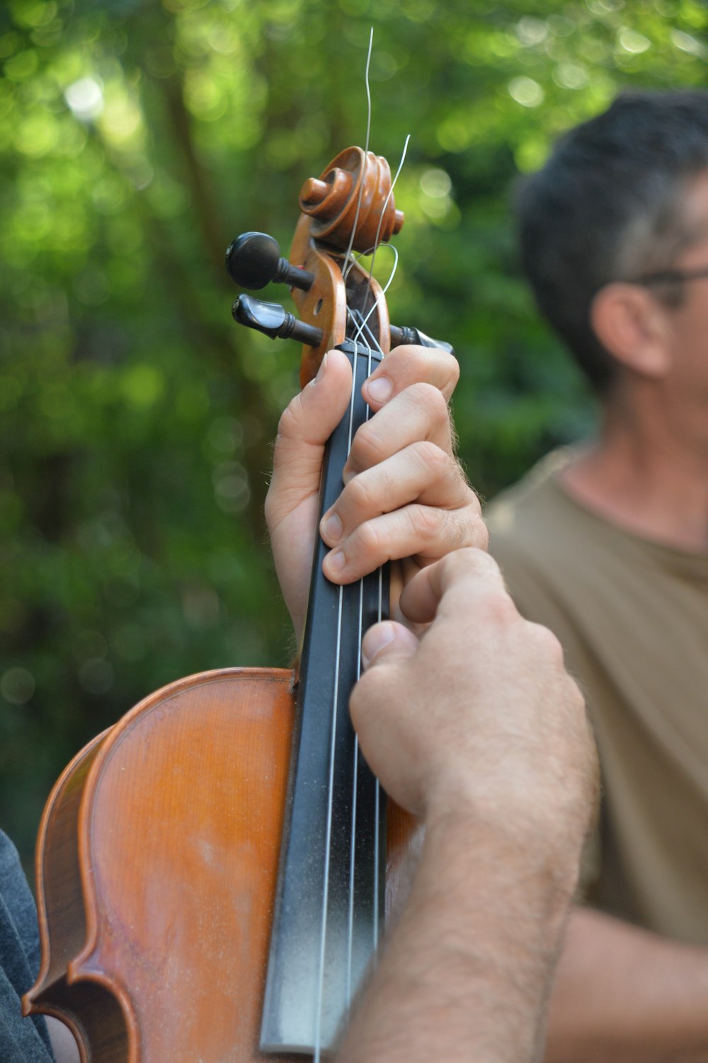 ein Mann, der eine Geige in der rechten Hand hält