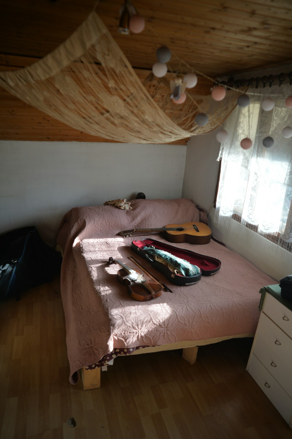ein Schlafzimmer mit einem Bett, einer Kommode und einem Fenster