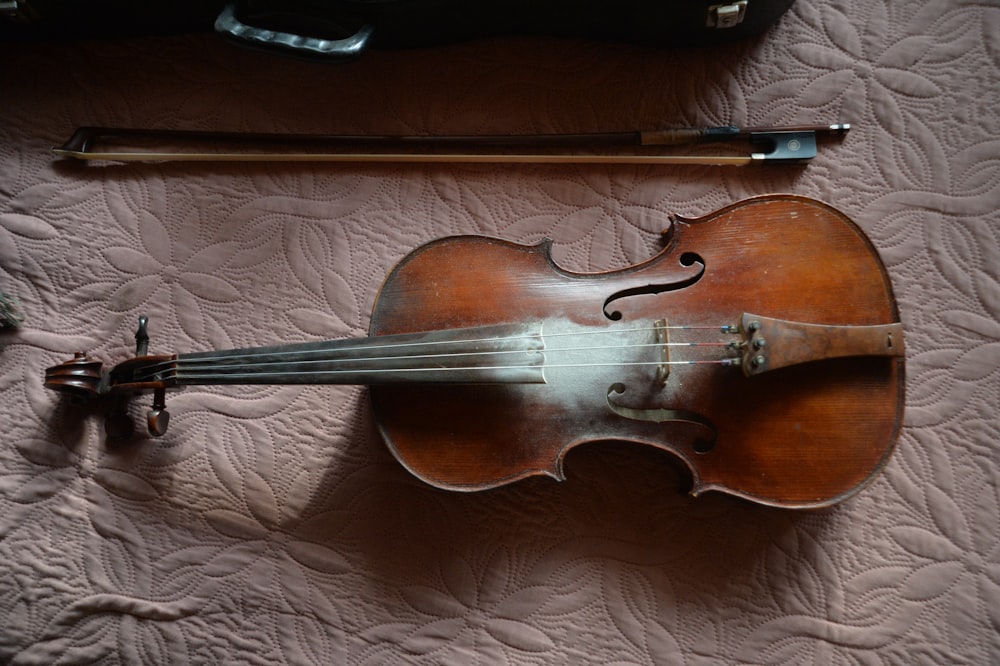 a violin and a violin case on a bed