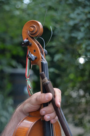 Volunteers helping children tune their string instruments before practice