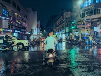 Urban street scene alive with motion and colorful reflections.