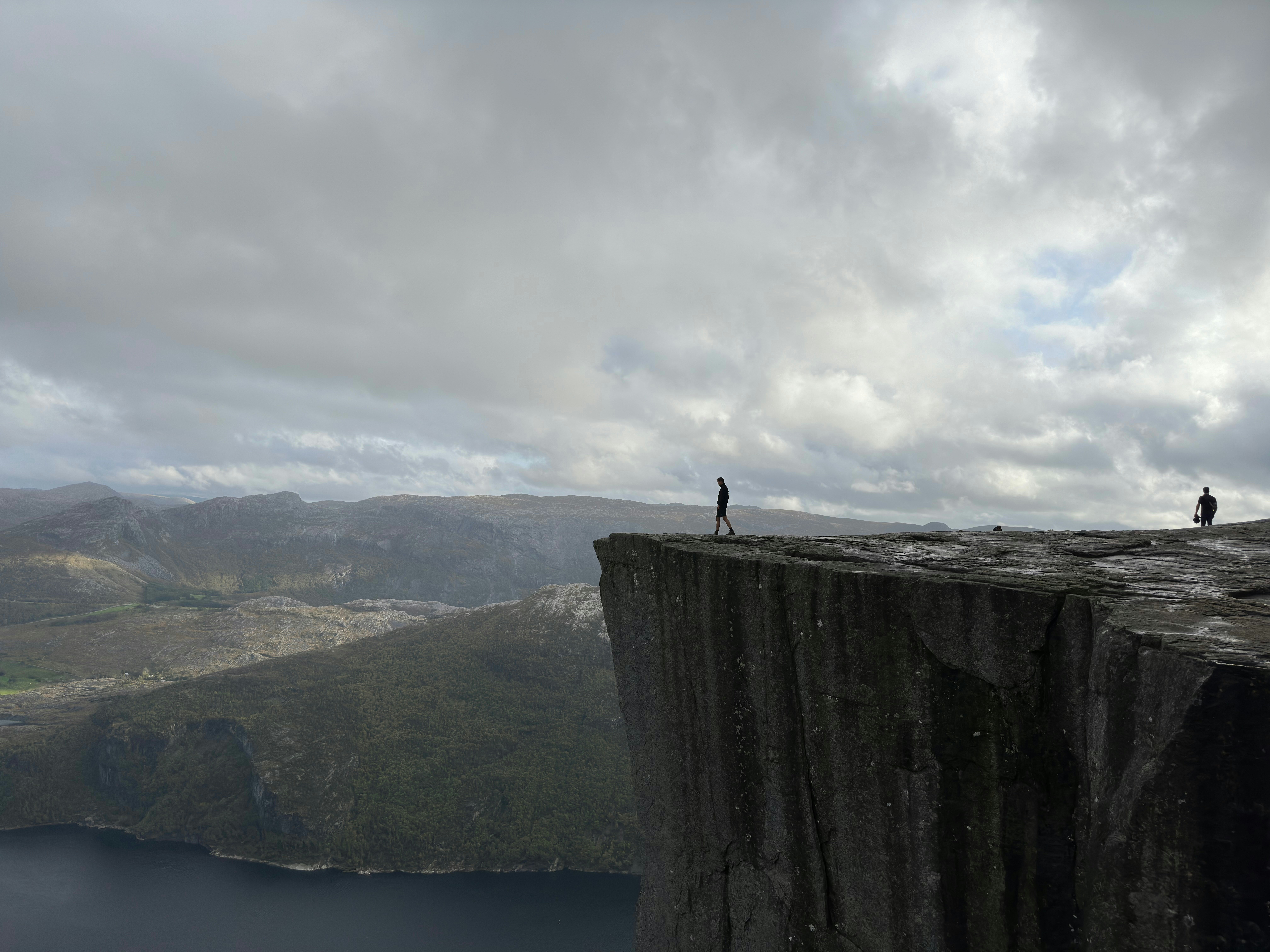 two people standing on the edge of a cliff