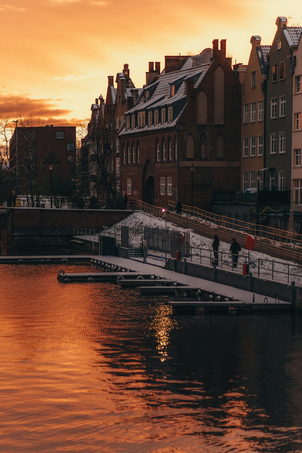 a body of water with a bridge and buildings in the background