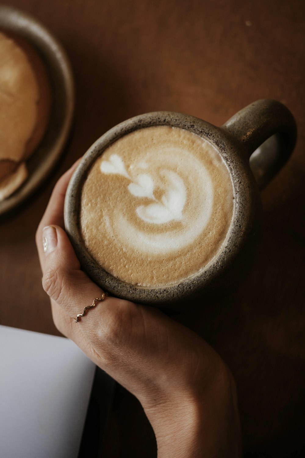 a person holding a cup of coffee in their hand