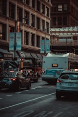 A convoy of production transport vehicles moving through a busy urban filming location.