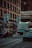 Tow truck transporting a vehicle on a busy urban street during daytime.