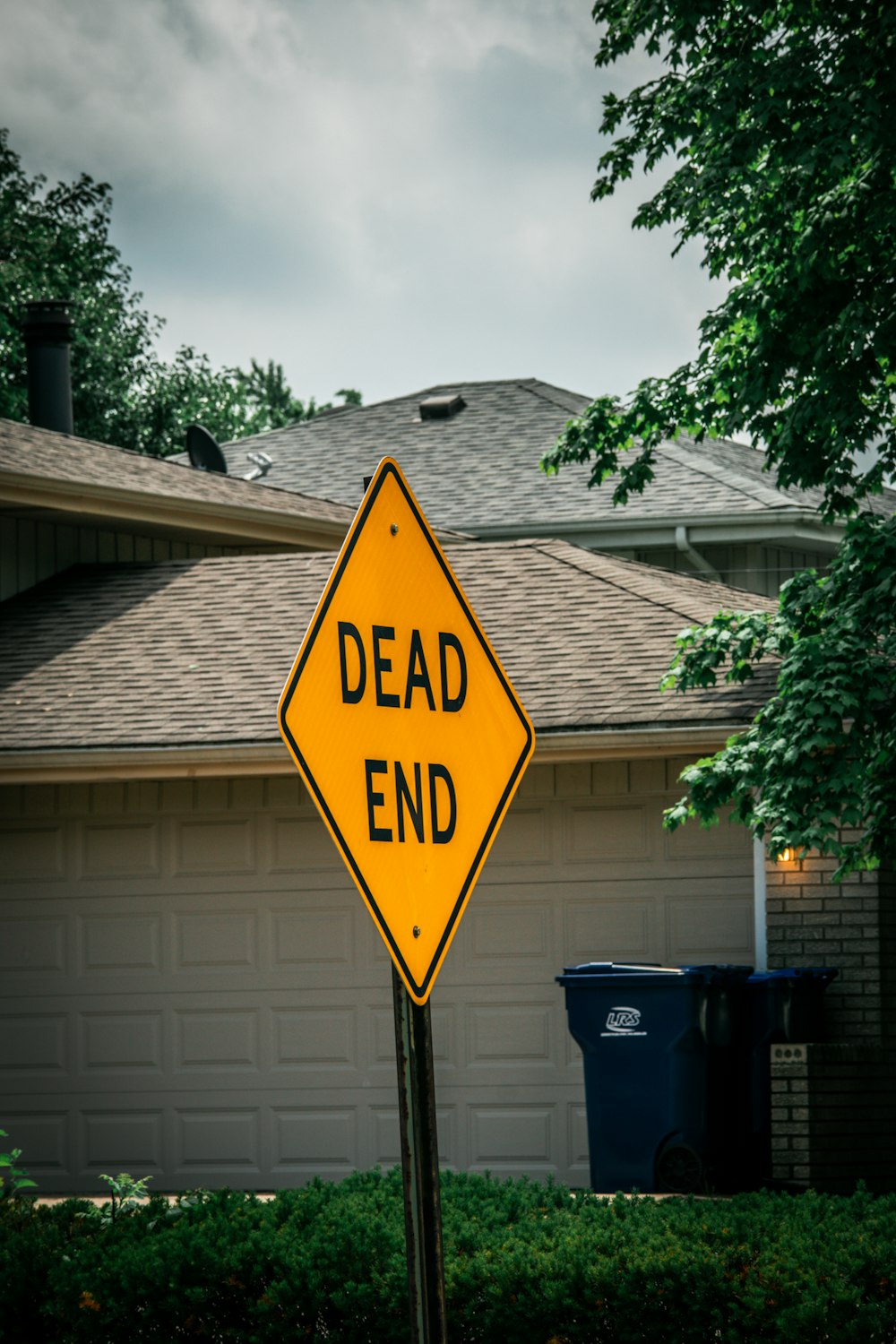 a dead end sign in front of a house