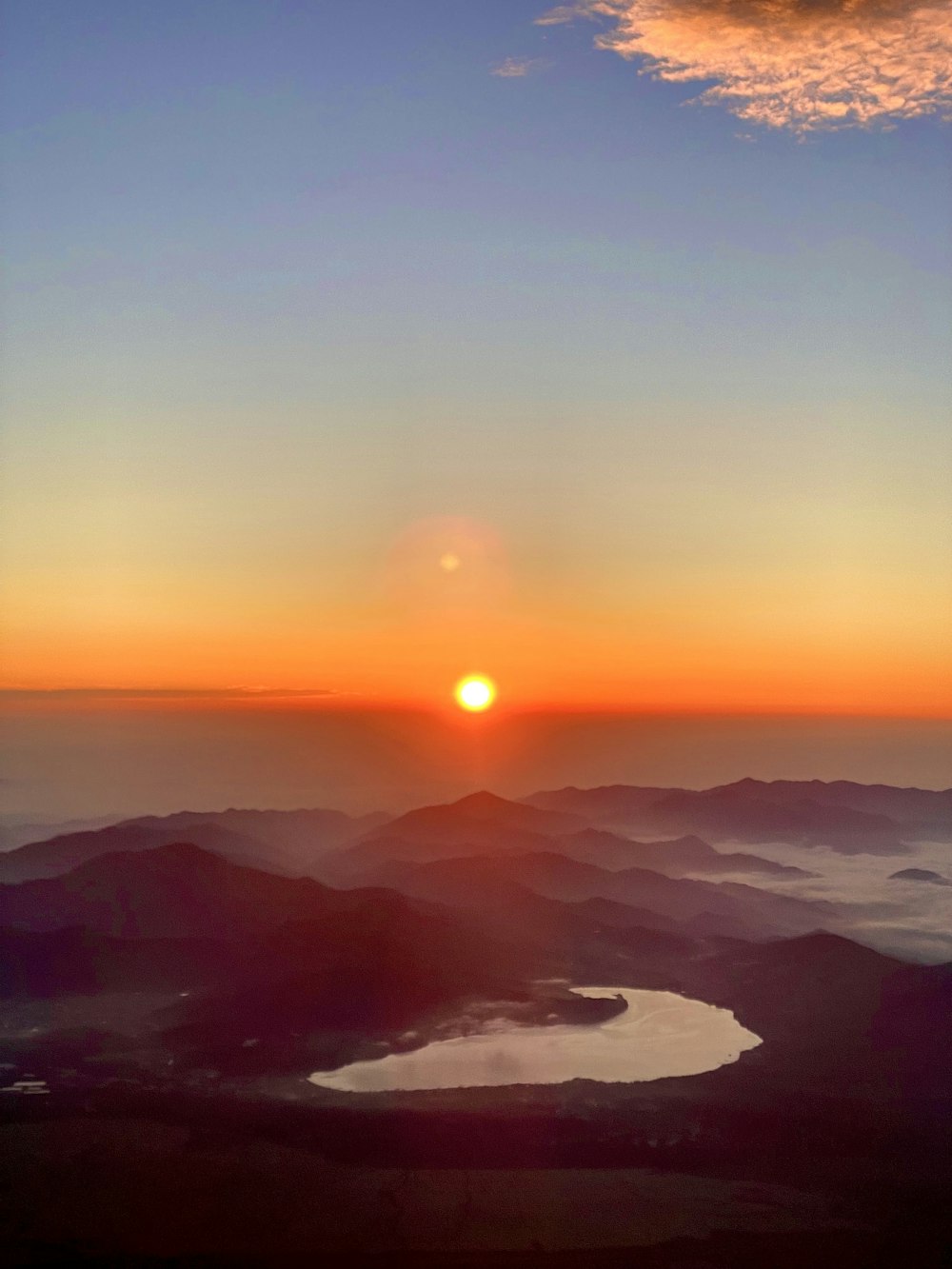 the sun is setting over a mountain range