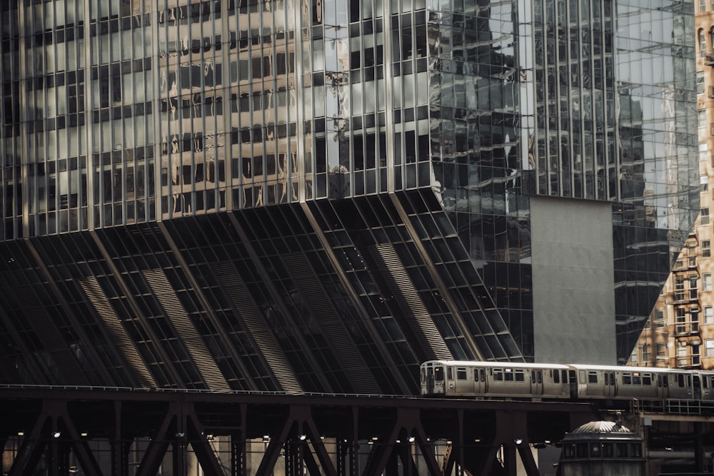 a train traveling over a bridge in front of tall buildings