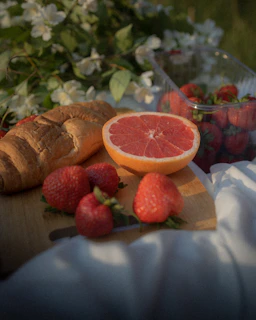 An outdoor picnic scene with a checkered tablecloth and a basket of fresh fruit.
