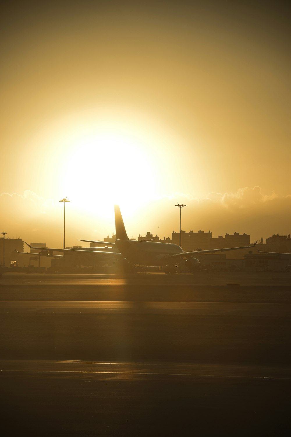 the sun is setting behind a plane on the runway