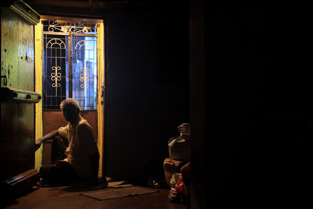 a person sitting on the floor in front of a door