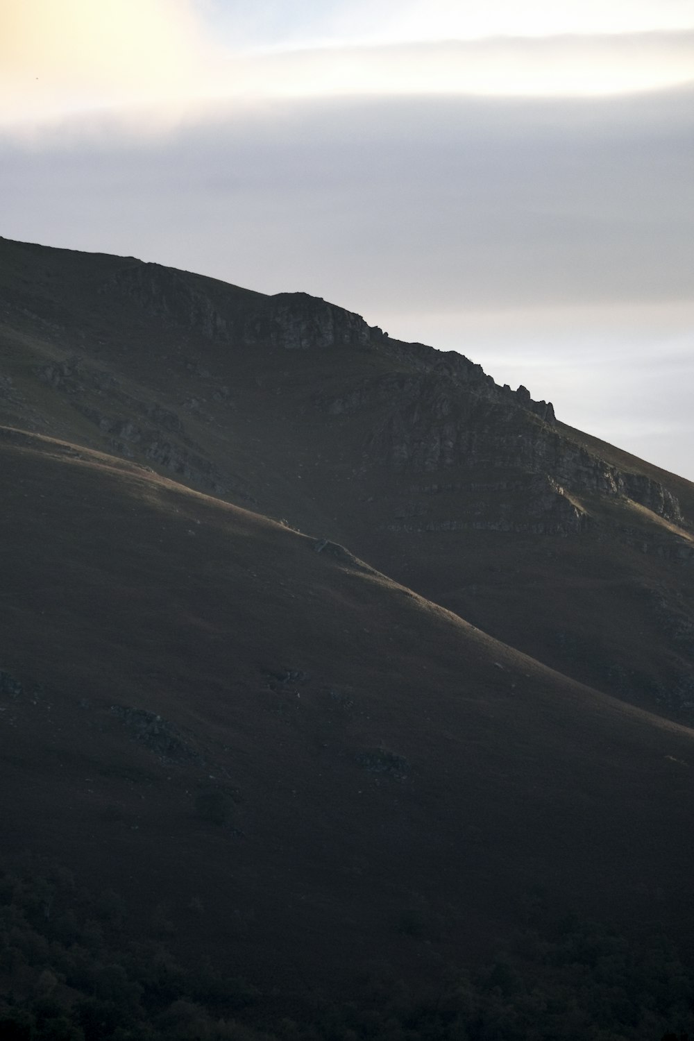 a mountain with a few clouds in the sky