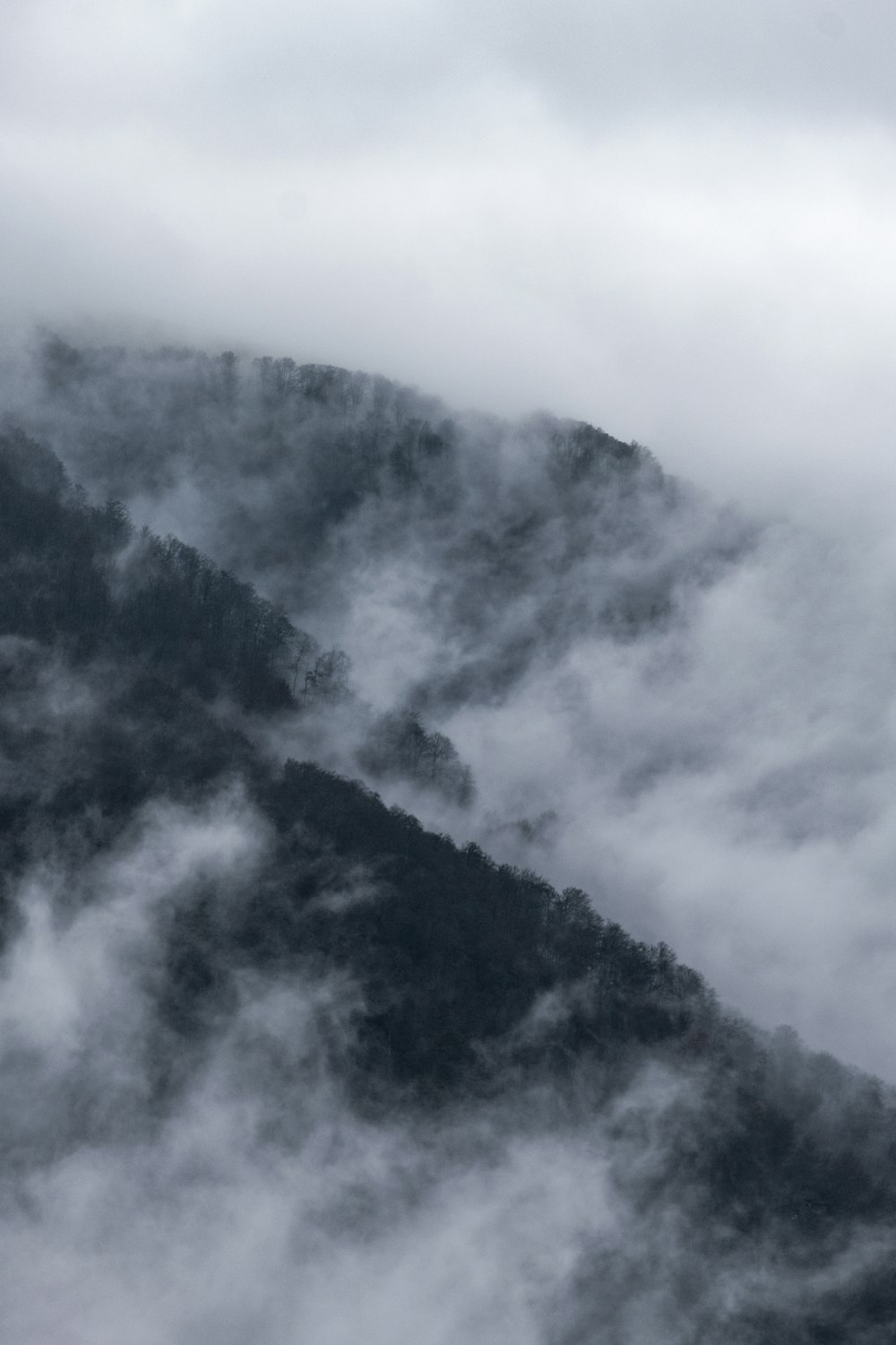 a view of a mountain covered in clouds