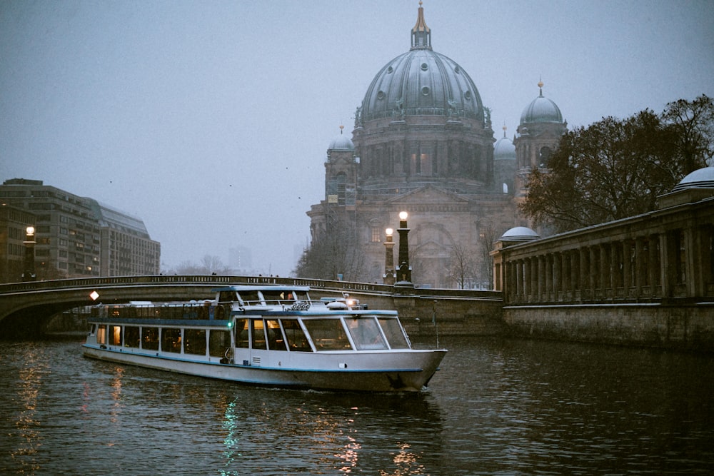 a boat traveling down a river next to a bridge