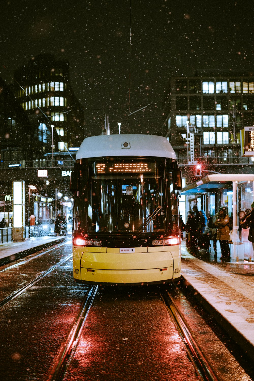 a yellow and white bus on a city street