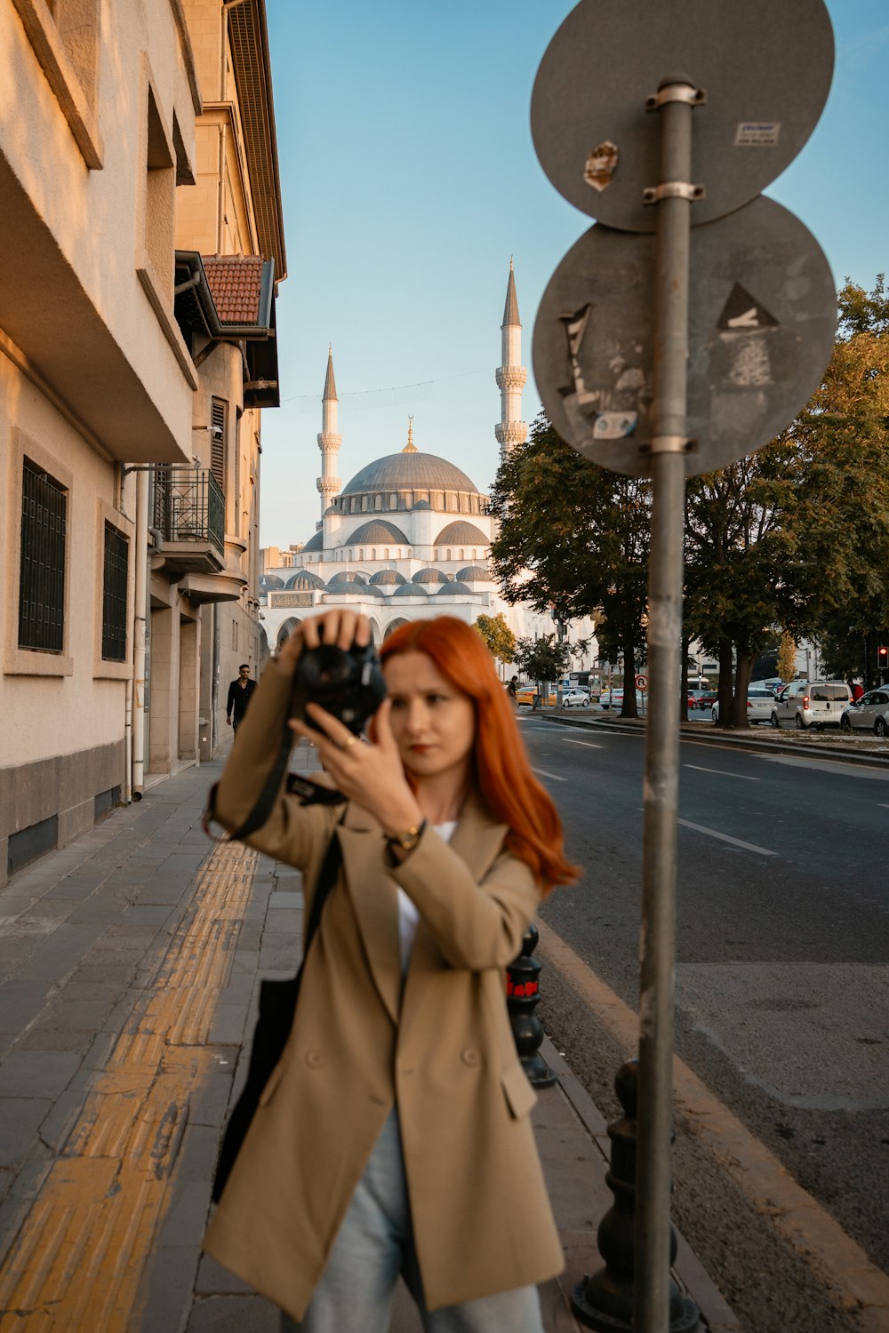 a woman taking a picture of a building with a camera